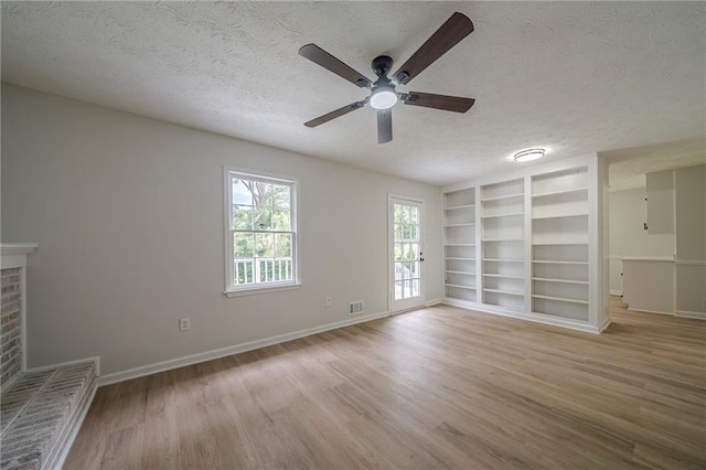 4732 Manly Ct, Stone Mountain, GA 30088 - empty room with a textured ceiling, ceiling fan, wood finished floors, built in features, and baseboards