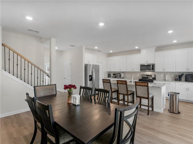 dining area with light hardwood / wood-style flooring and sink