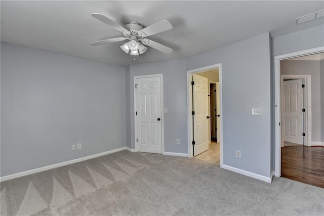 unfurnished bedroom featuring ceiling fan, light colored carpet, and a closet