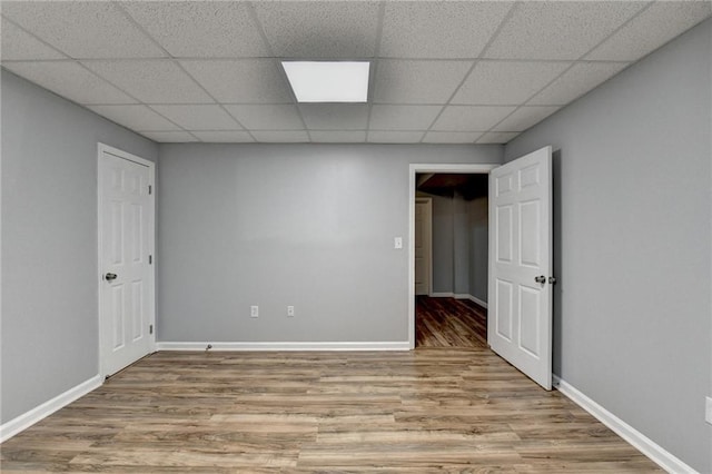 unfurnished room with hardwood / wood-style flooring and a paneled ceiling