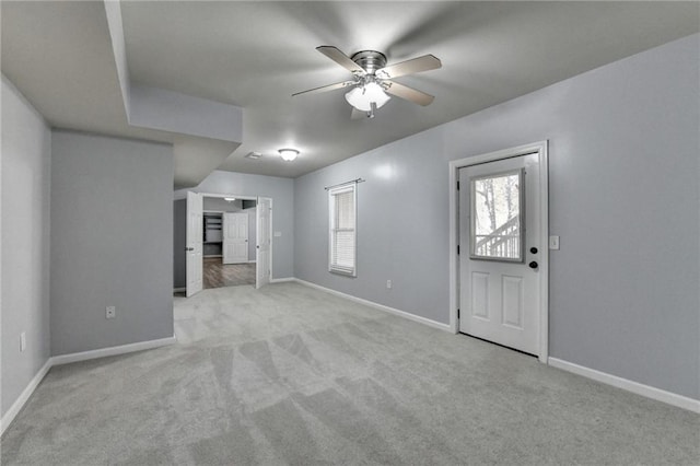 unfurnished living room featuring light carpet and ceiling fan