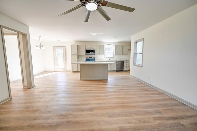 kitchen with gray cabinets, appliances with stainless steel finishes, a center island, and a wealth of natural light