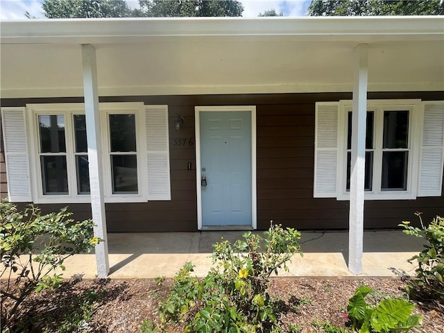 view of exterior entry featuring covered porch