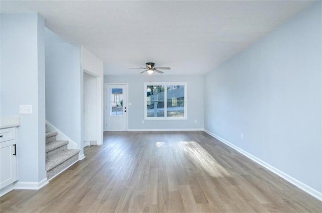 unfurnished living room with ceiling fan and light hardwood / wood-style flooring