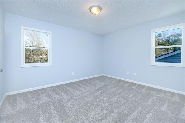 unfurnished room featuring carpet and a textured ceiling