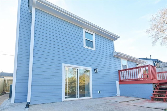 rear view of property with a deck and a patio area