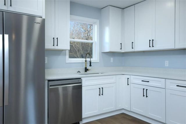 kitchen with white cabinets, stainless steel appliances, dark wood-type flooring, and sink