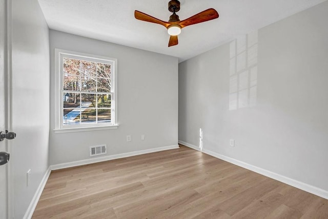 empty room featuring visible vents, baseboards, and wood finished floors