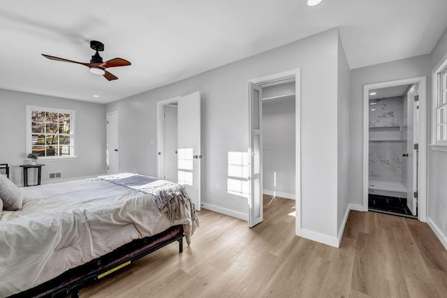 bedroom with a ceiling fan, visible vents, baseboards, light wood finished floors, and ensuite bath