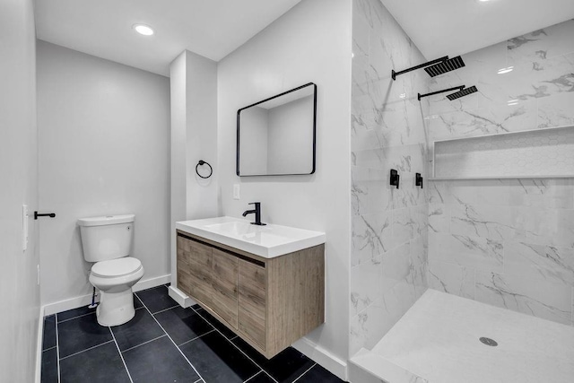 bathroom with toilet, vanity, baseboards, a marble finish shower, and tile patterned floors