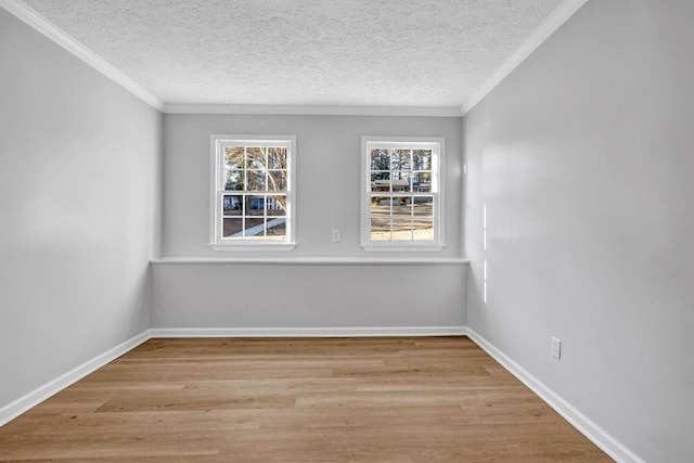 unfurnished room with crown molding, a textured ceiling, baseboards, and wood finished floors