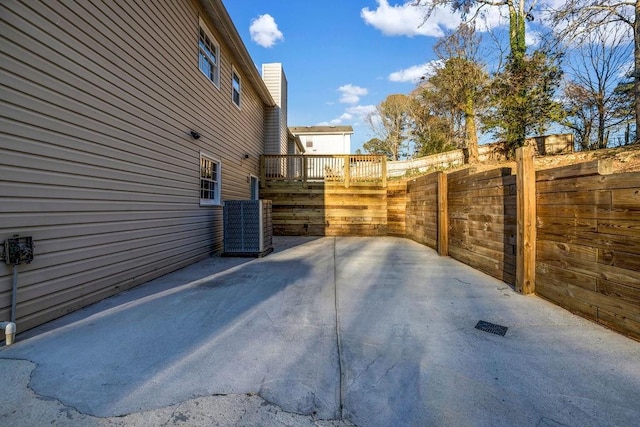 view of patio with fence, a deck, and central air condition unit