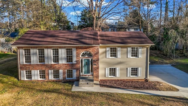 split foyer home with brick siding and a front yard