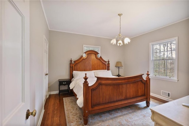 bedroom featuring hardwood / wood-style floors, an inviting chandelier, and ornamental molding