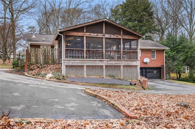 view of front of home featuring a sunroom and a garage