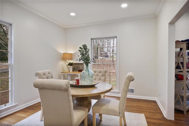 dining space featuring hardwood / wood-style floors and ornamental molding