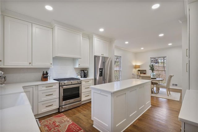 kitchen with dark hardwood / wood-style flooring, a kitchen island, white cabinets, and premium appliances