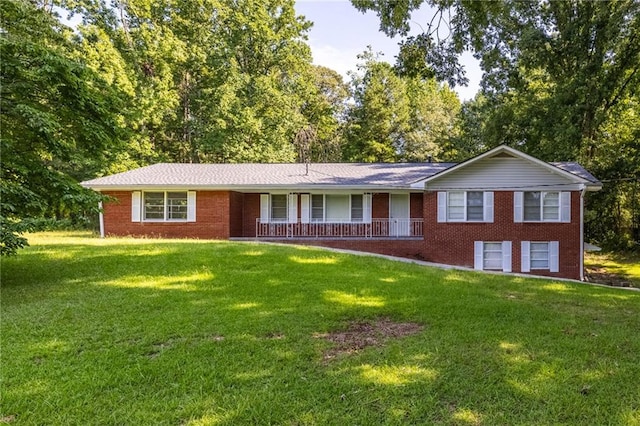 ranch-style house featuring covered porch, brick siding, and a front lawn