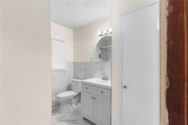 full bathroom with a textured ceiling, toilet, vanity, tile walls, and marble finish floor