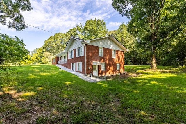 view of side of home with a yard and brick siding