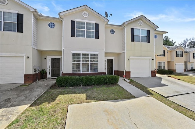 multi unit property with concrete driveway, brick siding, an attached garage, and stucco siding