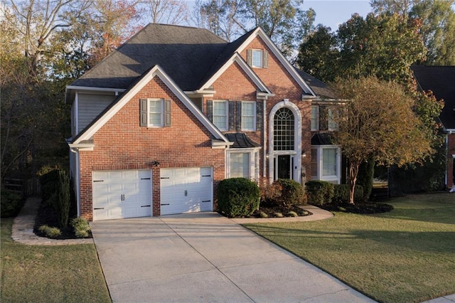 view of property featuring a garage and a front lawn