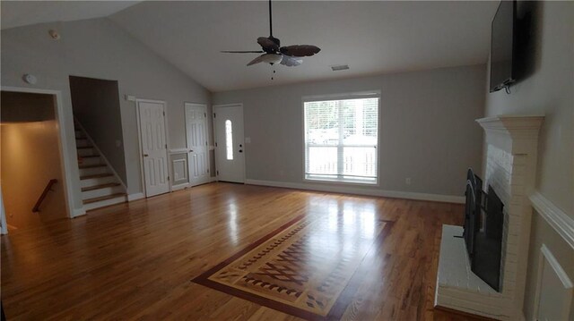 2477 Briar Valley Way, Dacula, GA 30019 - unfurnished living room with ceiling fan, a fireplace, wood finished floors, stairway, and lofted ceiling