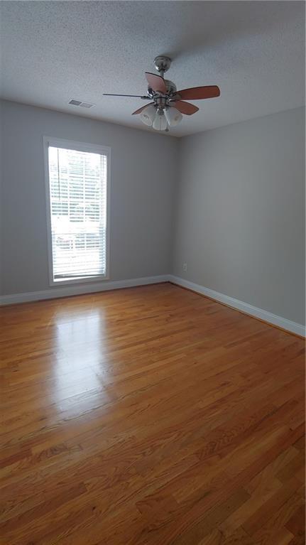 2477 Briar Valley Way, Dacula, GA 30019 - spare room featuring a textured ceiling, baseboards, visible vents, and wood finished floors