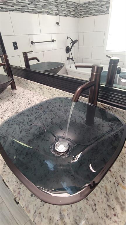 2477 Briar Valley Way, Dacula, GA 30019 - room details with a sink and tasteful backsplash