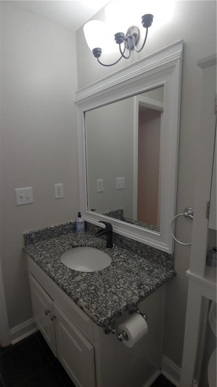 2477 Briar Valley Way, Dacula, GA 30019 - bathroom featuring baseboards, a chandelier, tile patterned flooring, and vanity