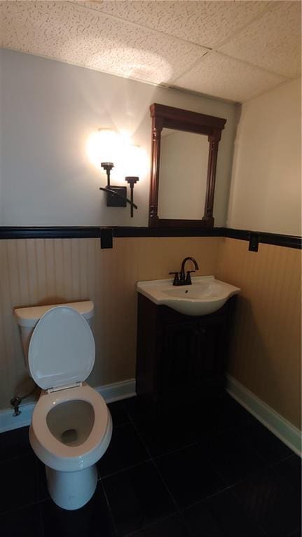 2477 Briar Valley Way, Dacula, GA 30019 - bathroom with wainscoting, a sink, tile patterned flooring, toilet, and a drop ceiling