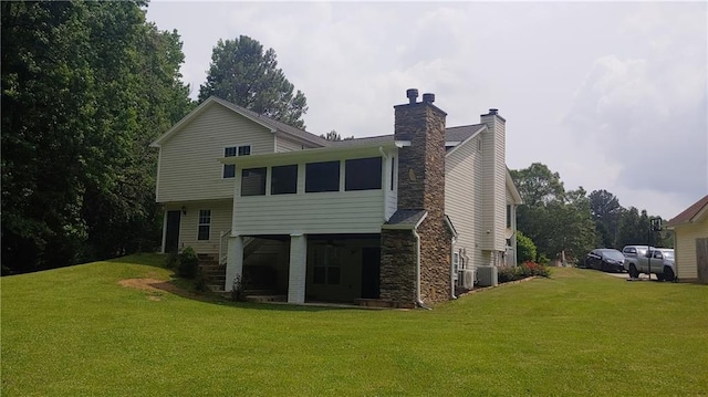 2477 Briar Valley Way, Dacula, GA 30019 - rear view of property featuring stone siding, central AC, a yard, and a chimney