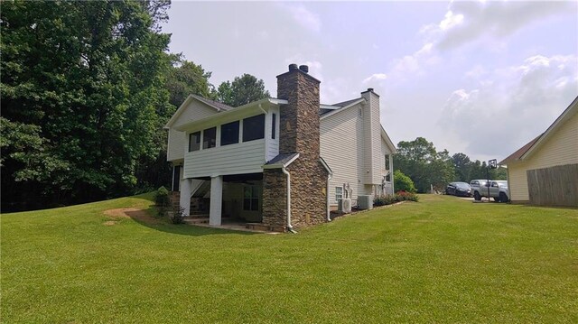 2477 Briar Valley Way, Dacula, GA 30019 - rear view of house featuring a lawn, a chimney, central AC unit, and stone siding