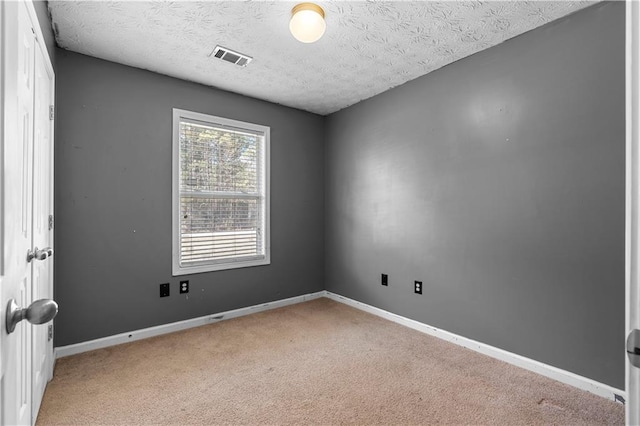 carpeted spare room featuring a textured ceiling