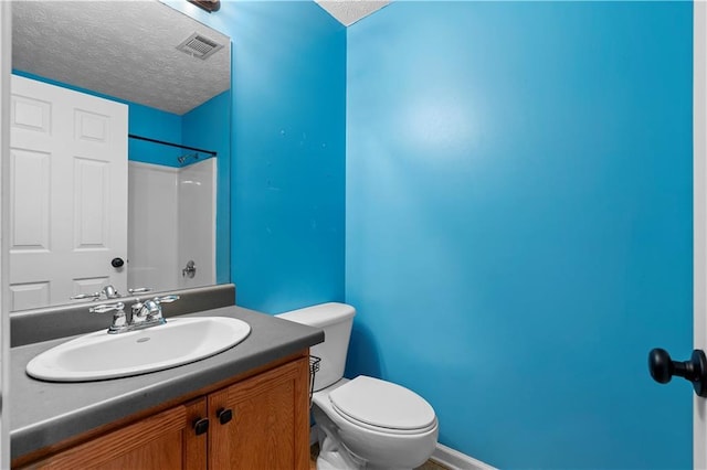 bathroom featuring a shower, a textured ceiling, toilet, and vanity