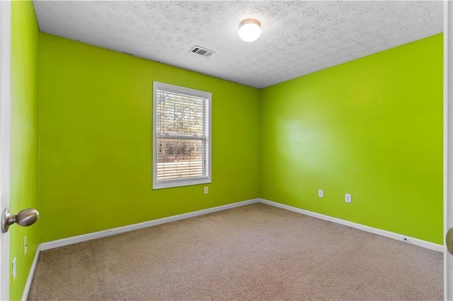 empty room with a textured ceiling and carpet