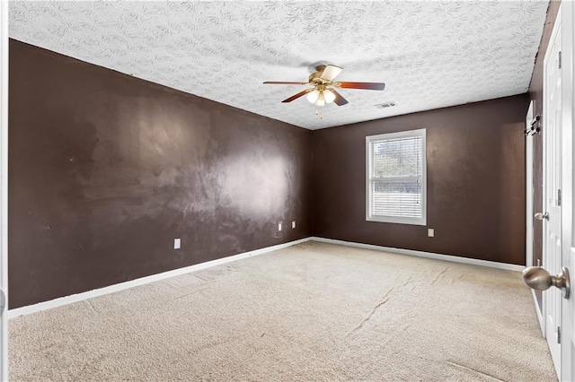 empty room featuring ceiling fan, carpet, and a textured ceiling