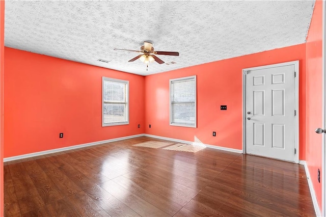 unfurnished room featuring a textured ceiling, dark hardwood / wood-style floors, and ceiling fan