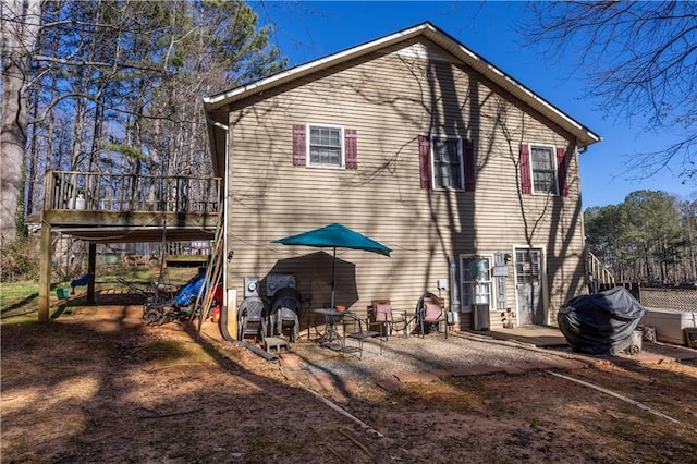 view of property exterior featuring a patio area and a wooden deck