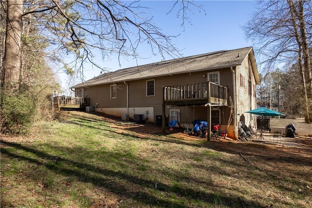 back of property with central air condition unit, a lawn, and a wooden deck