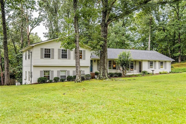 split level home featuring brick siding and a front lawn