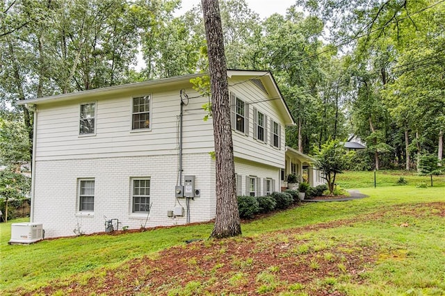 view of side of home featuring a lawn and brick siding