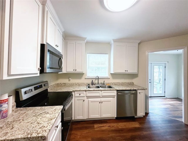 kitchen featuring a sink, plenty of natural light, dark wood-style floors, appliances with stainless steel finishes, and white cabinets