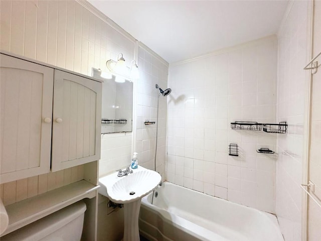 full bathroom featuring a sink, toilet, tile walls, and shower / washtub combination