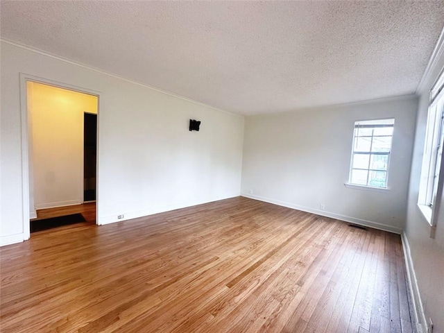 unfurnished room featuring baseboards, wood-type flooring, and a textured ceiling