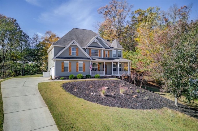 view of front of home with a porch, concrete driveway, and a front yard