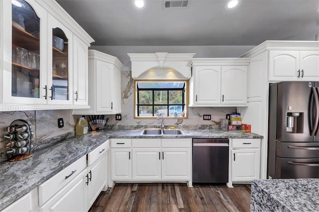 kitchen featuring dark hardwood / wood-style floors, dark stone counters, sink, white cabinets, and appliances with stainless steel finishes