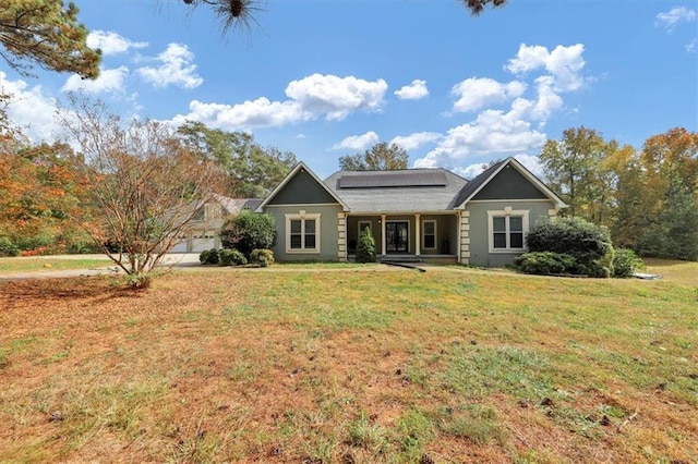 view of front of house with a front lawn and solar panels