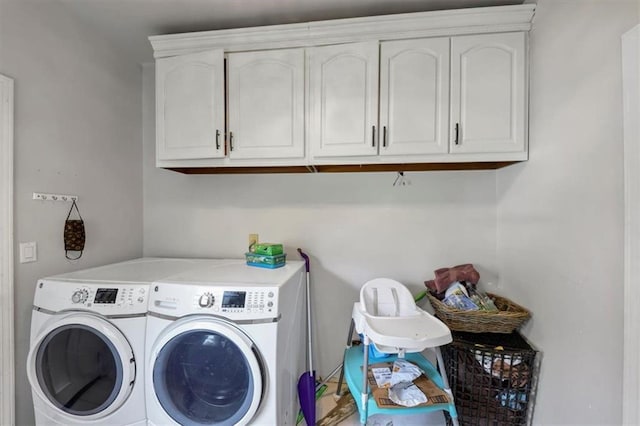 washroom with washer and clothes dryer and cabinets