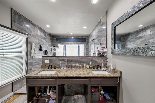 bathroom with vanity, walk in shower, and tile walls